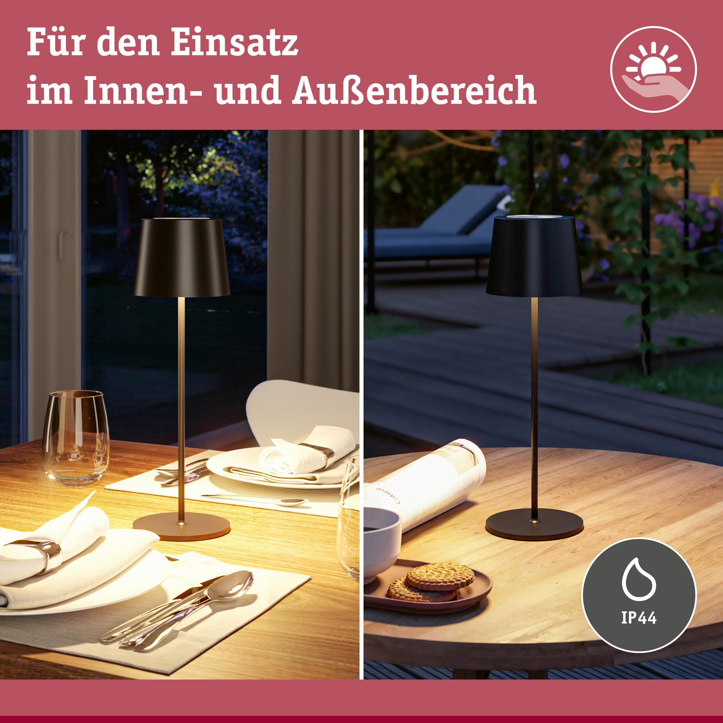 Czarna lampa stołowa na drewnianym stole, wewnątrz i na zewnątrz.