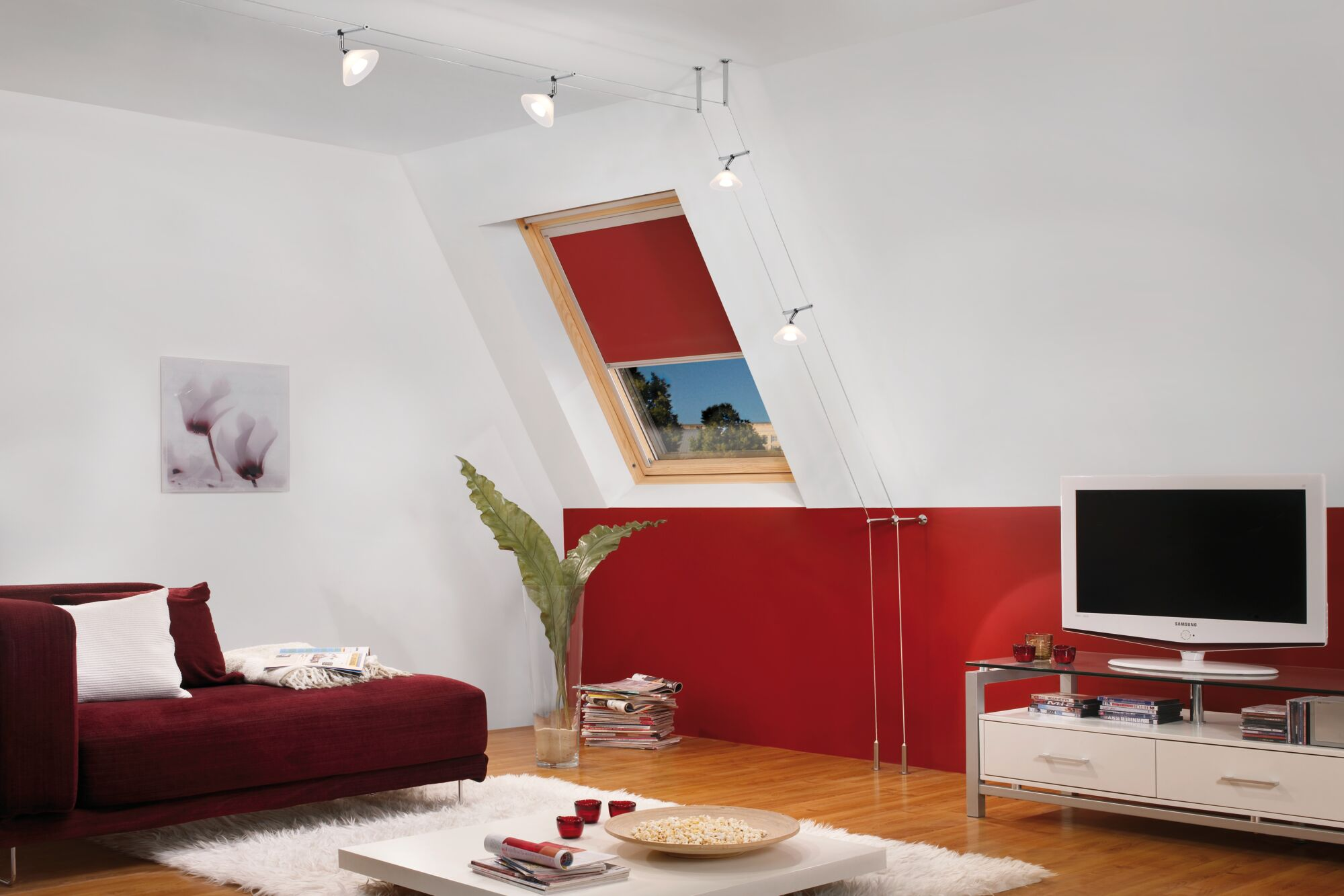 Un soggiorno con divano rosso, TV, finestra e opera d'arte.