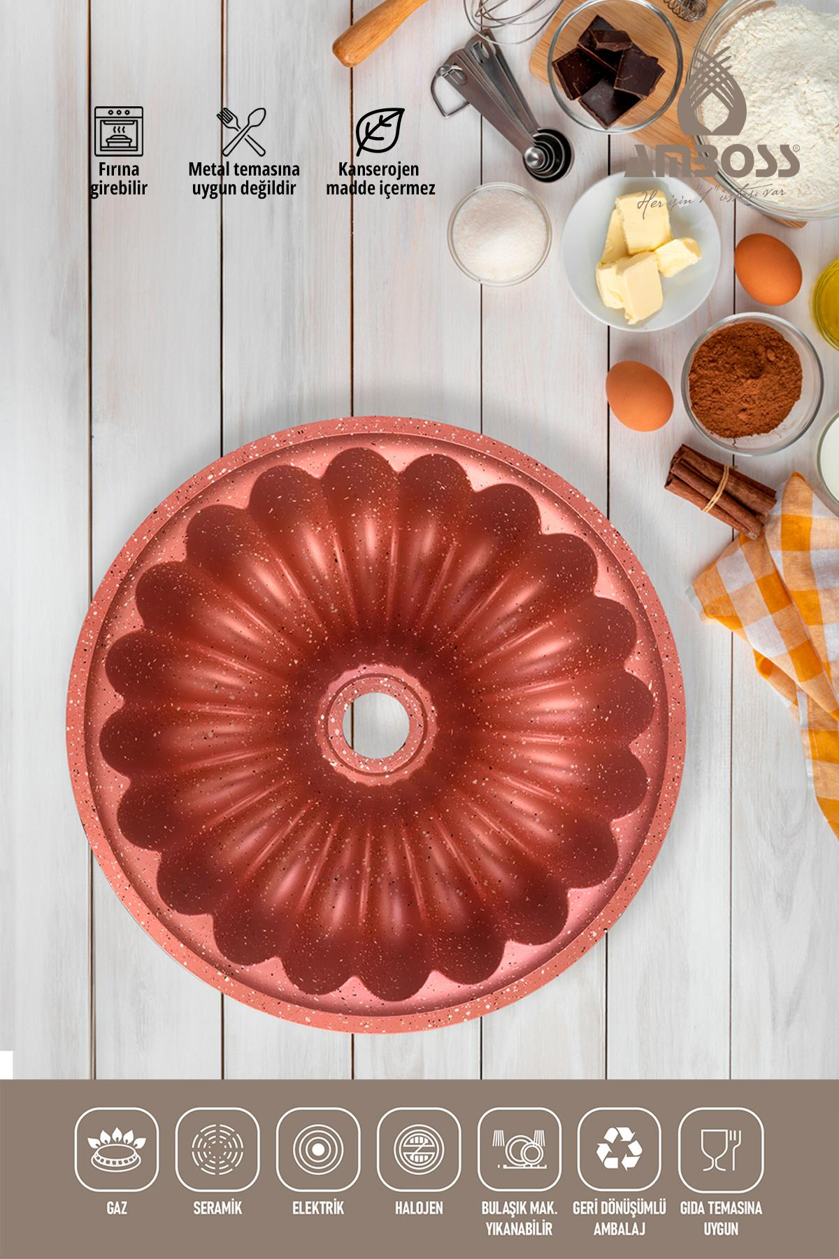 Pembe renkli kek kalıbı, üzerinde pişirme malzemeleri olan ahşap masa.