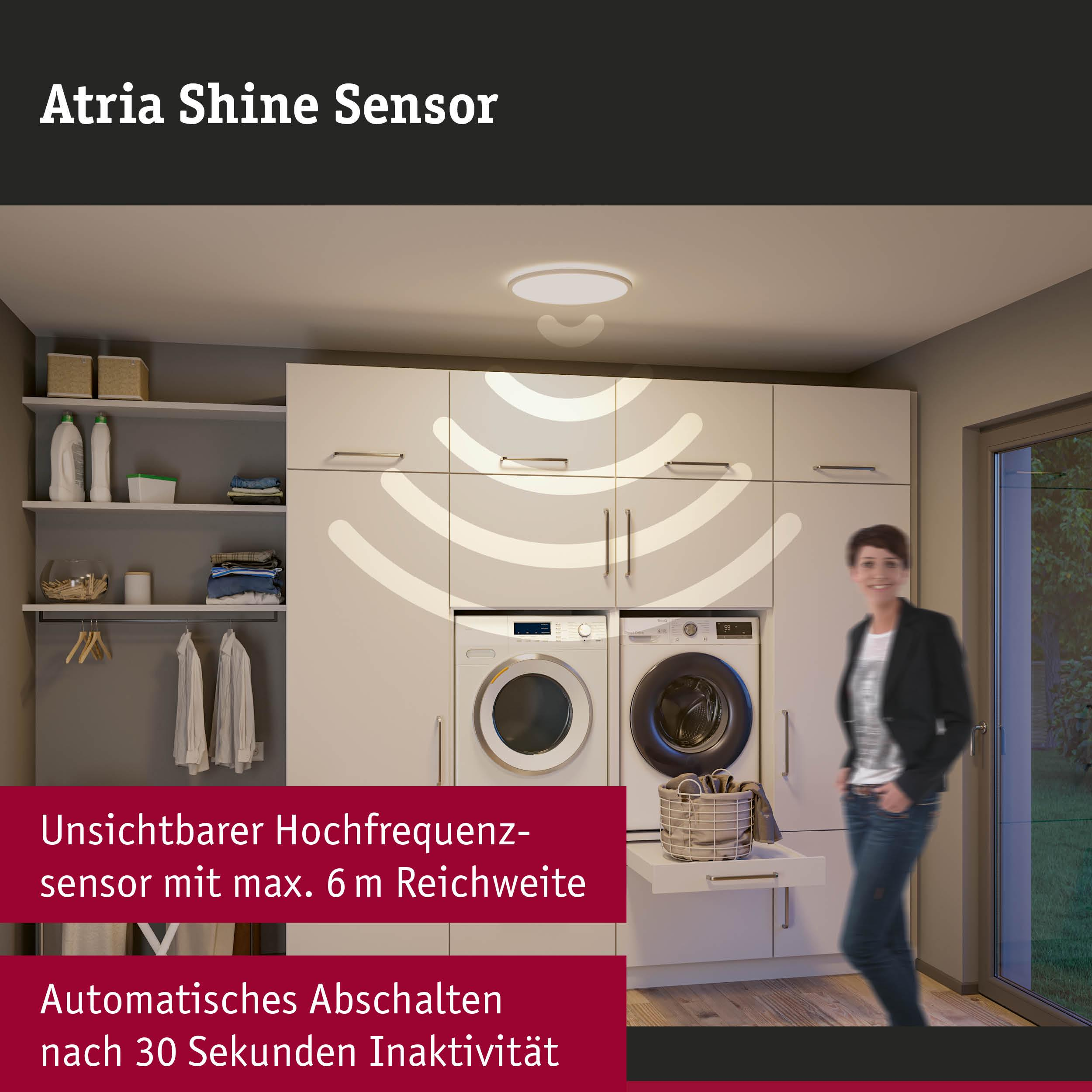 Waschküche mit Waschmaschine, Trockner und Frau. Sensor über den Geräten.