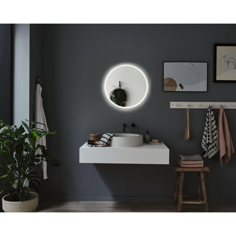 Salle de bain moderne avec vanité flottante, miroir rond illuminé, lavabo et serviettes.