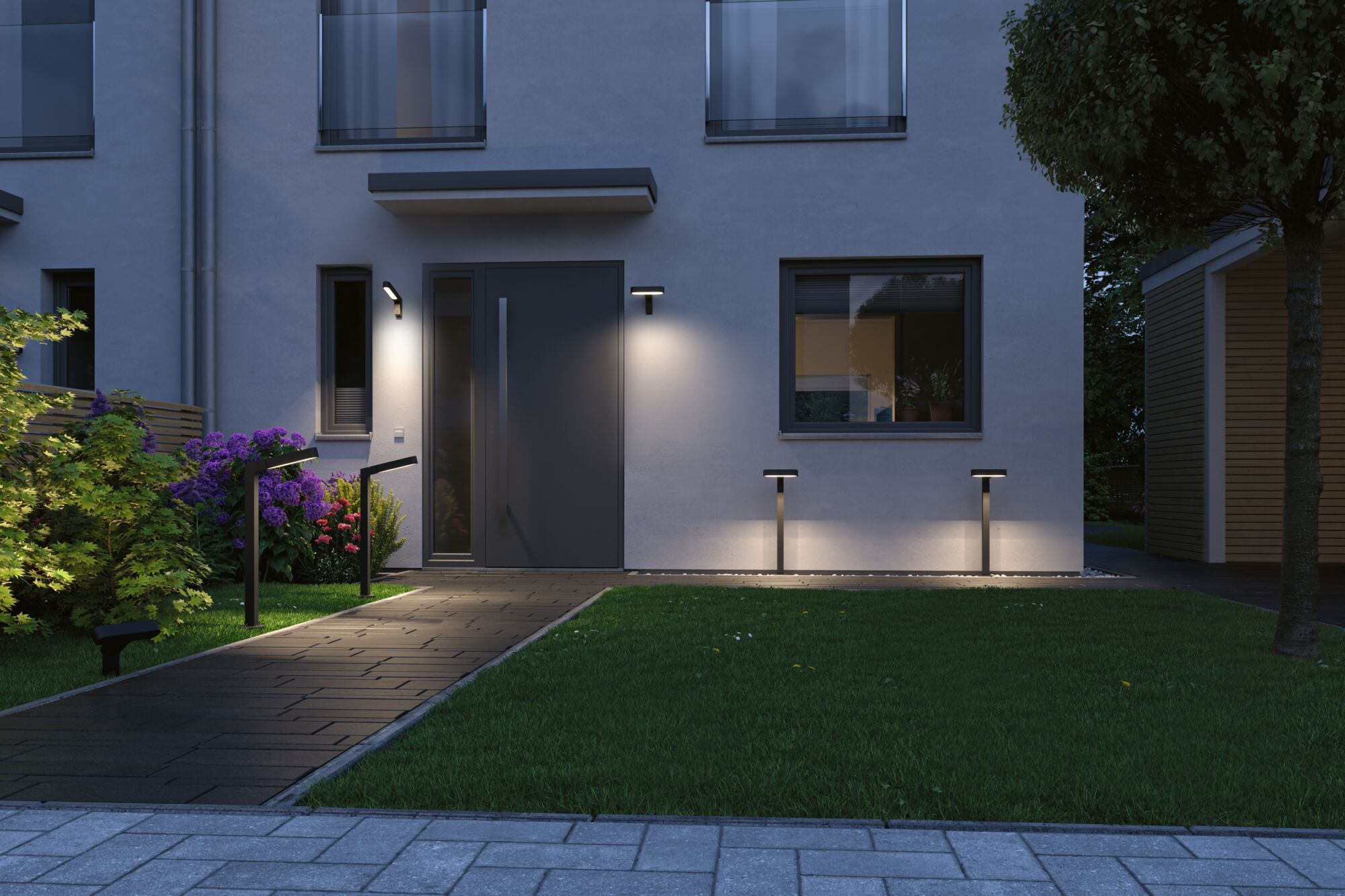Moderne Hausfront mit Wegbeleuchtung am Abend, dunkler Weg, grüner Rasen.