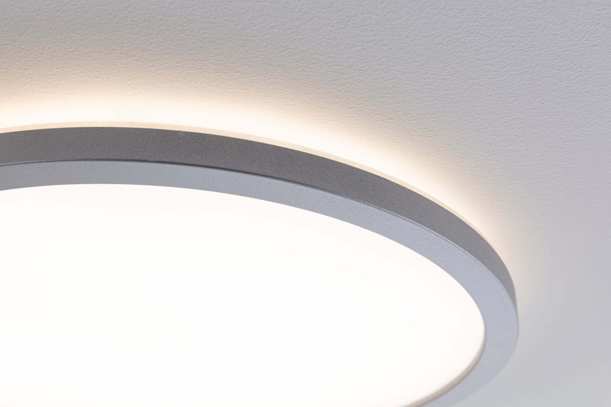 Zbliżenie lampy sufitowej z szarą ramą i jasnym oświetleniem.