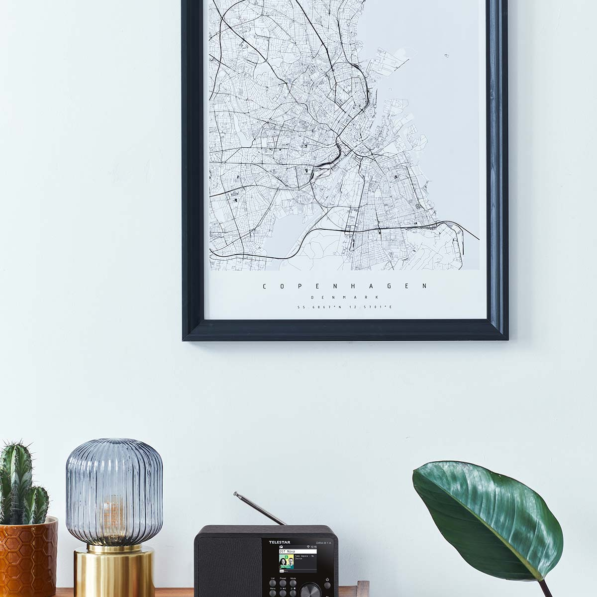 Karte von Kopenhagen an der Wand, Radio, Lampe und Kakteen auf dem Tisch.