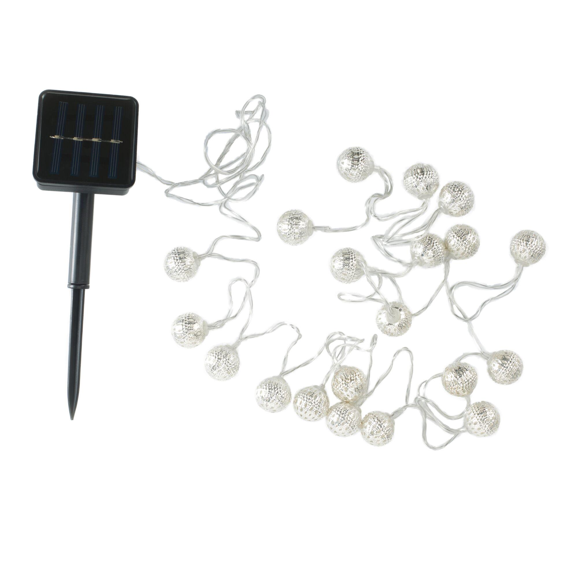 Panel słoneczny z szpilką i lampkami sznurkowymi ze srebrnymi kulkami.