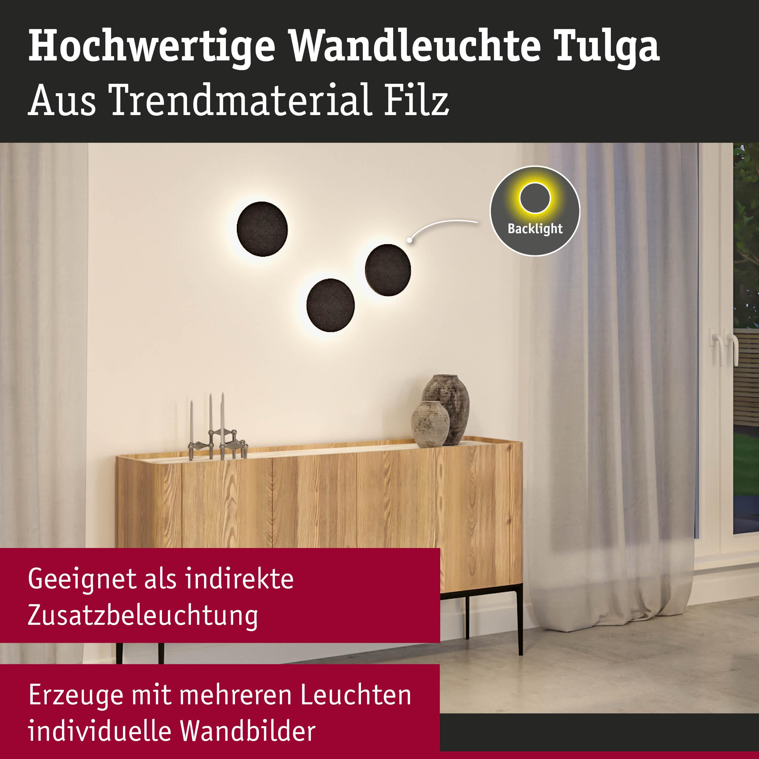 Drei runde Wandleuchten mit schwarzem Filz und indirekter Beleuchtung über einem Holzschrank.