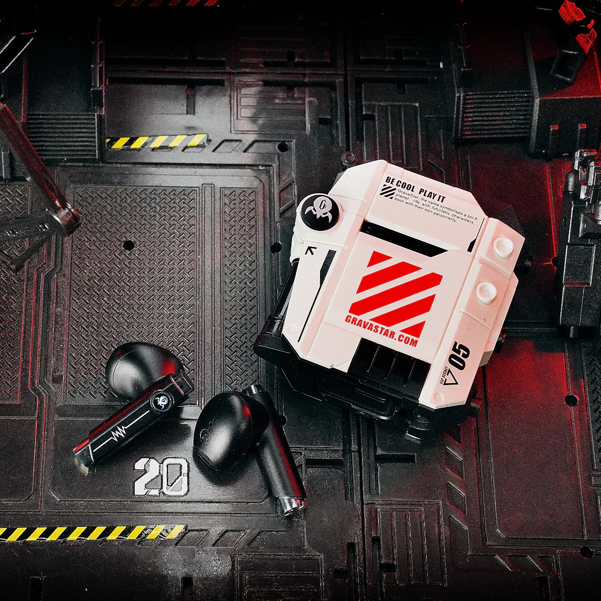 Czarne słuchawki i białe etui z czerwonymi paskami na ciemnym, metalicznym tle.