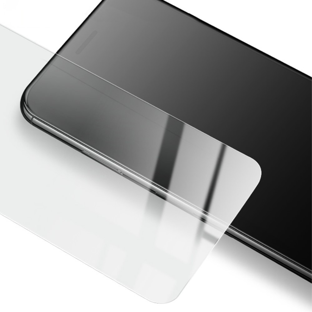 Un protecteur d'écran transparent repose sur un smartphone noir.