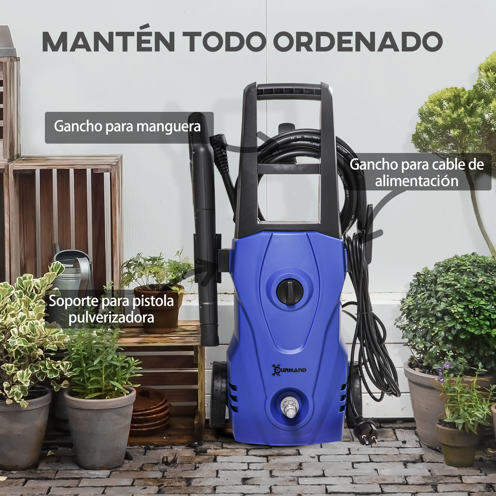 Una hidrolimpiadora azul está sobre un camino adoquinado junto a plantas.