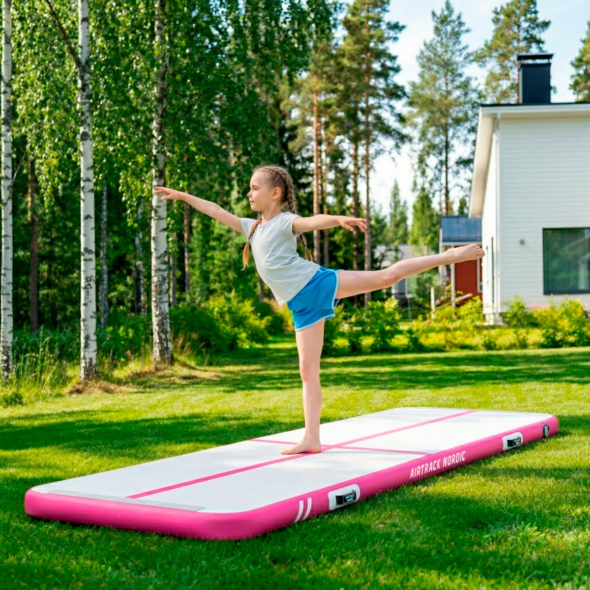 Dziewczynka ćwiczy jogę na dmuchanej macie w ogrodzie