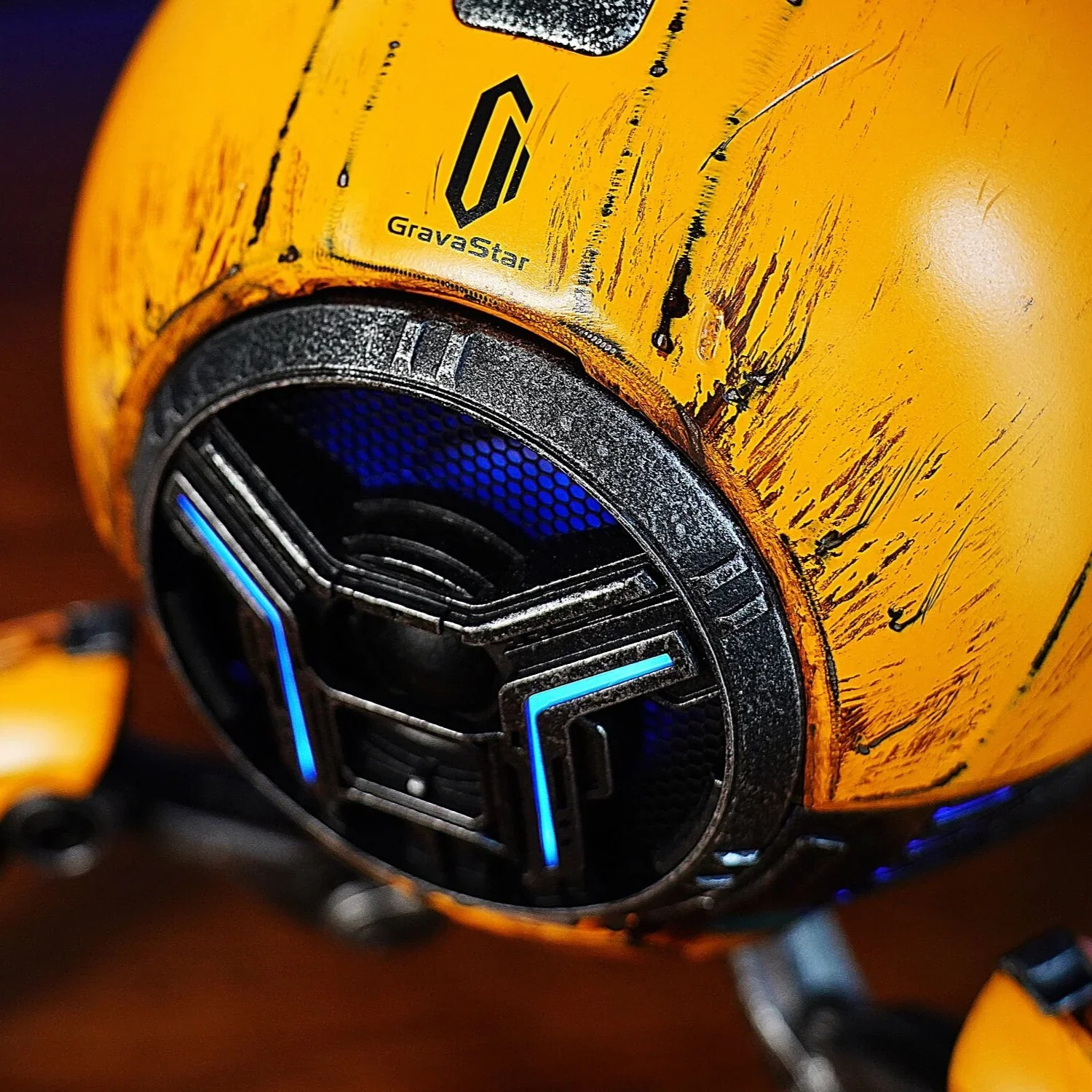 Żółta kula z niebieskimi światłami i zadrapaniami. Widoczne logo i tekst.