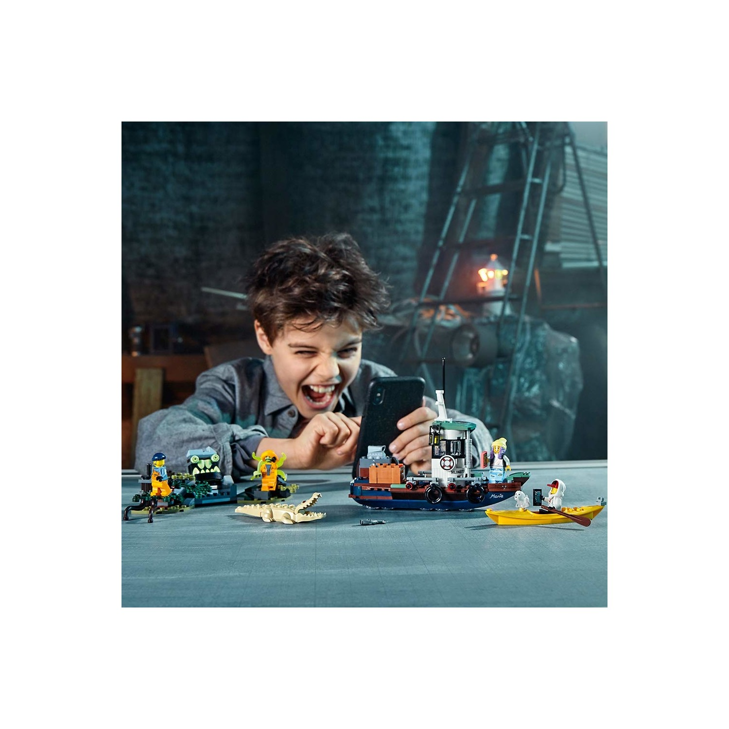 Çocuk Lego oyuncaklarıyla oynuyor: tekne, kano, timsah, figürler.