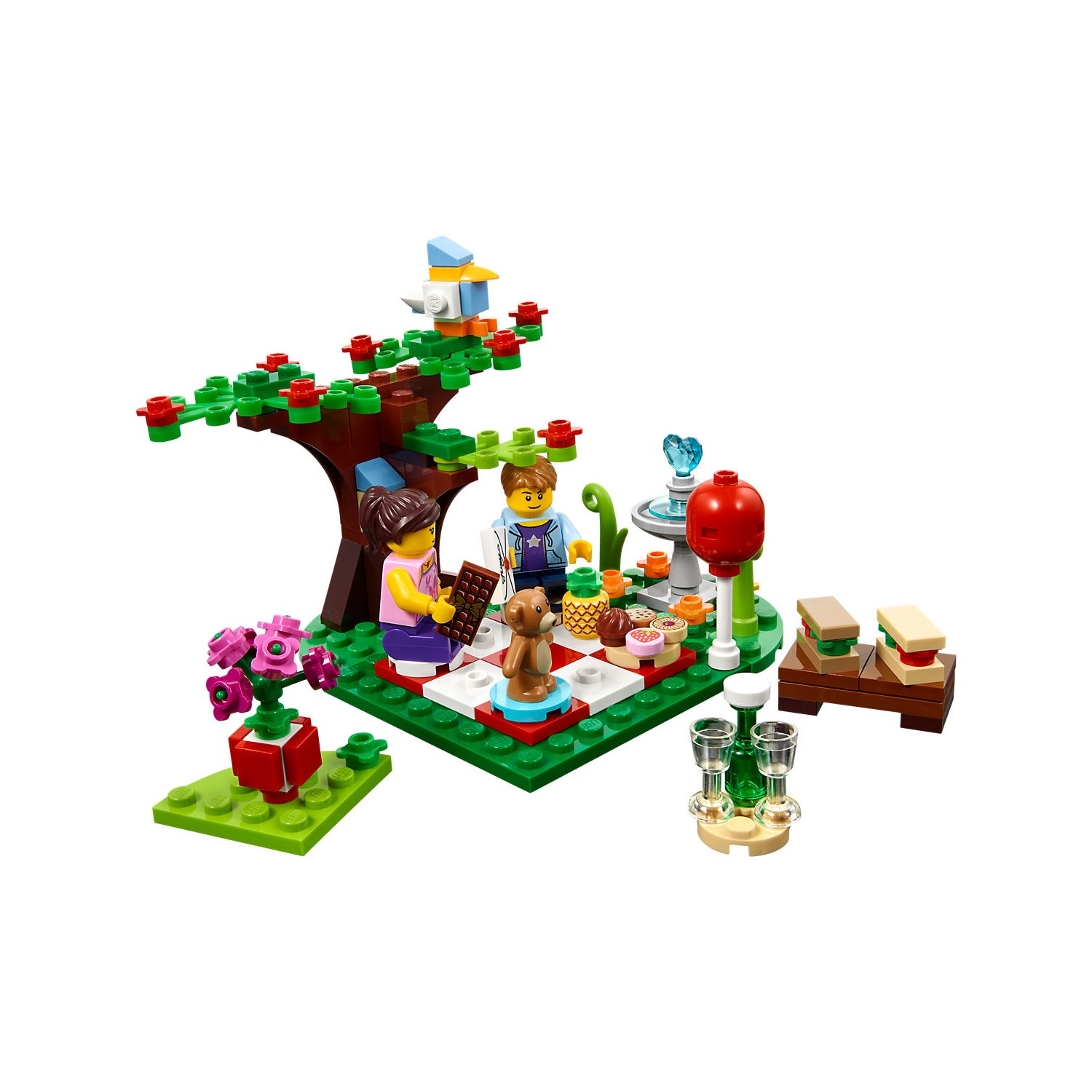 İnsanlar, köpek, yiyecek, ağaç, çiçekler ve kuş ile Lego piknik sahnesi.