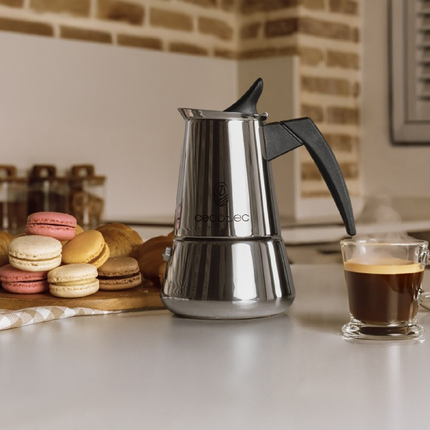 Una macchina da caffè con pasticcini e una tazza di caffè su un piano di lavoro.
