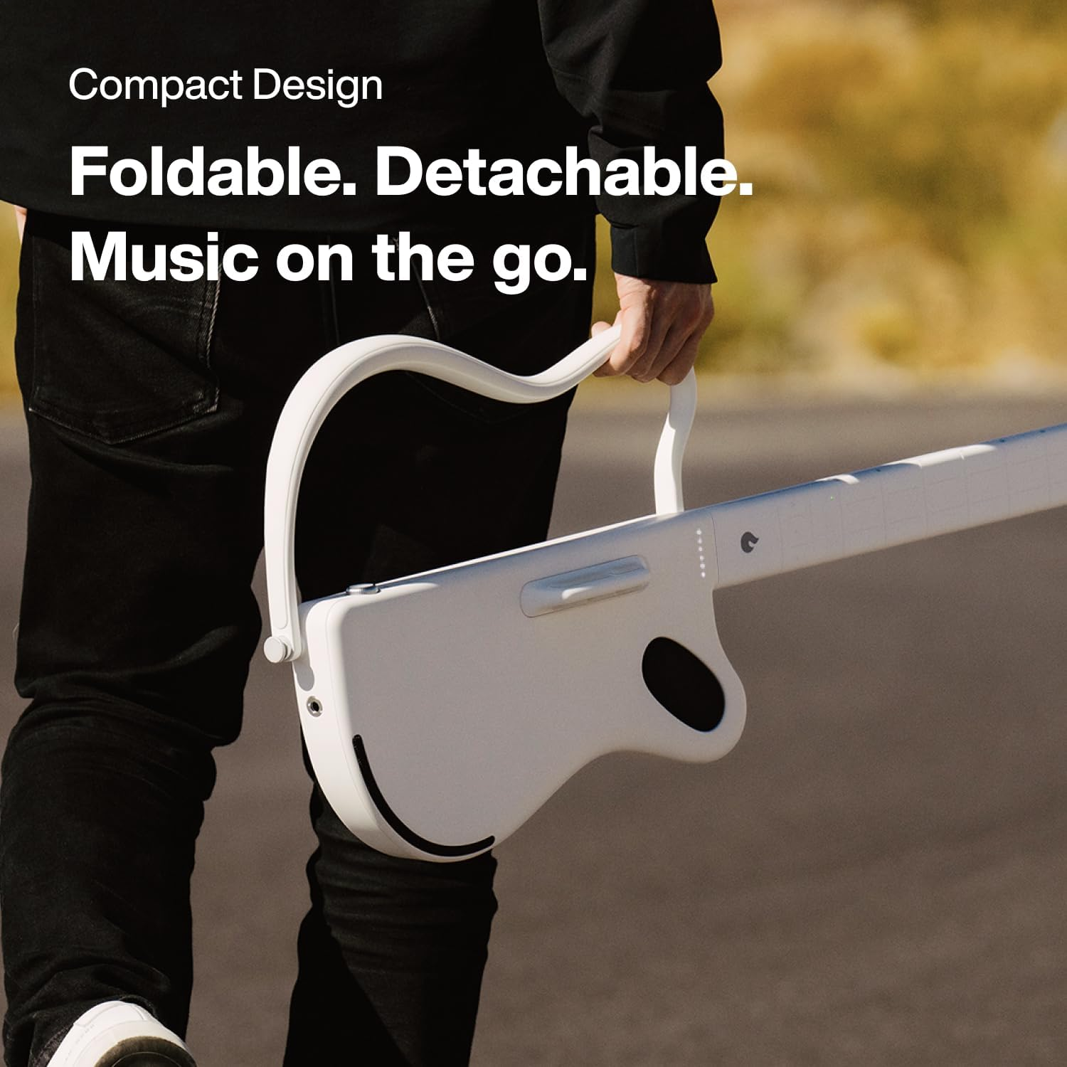 Persoon draagt witte opvouwbare gitaar. Tekst: Compact Design. Opvouwbaar. Afneembaar. Muziek onderweg.