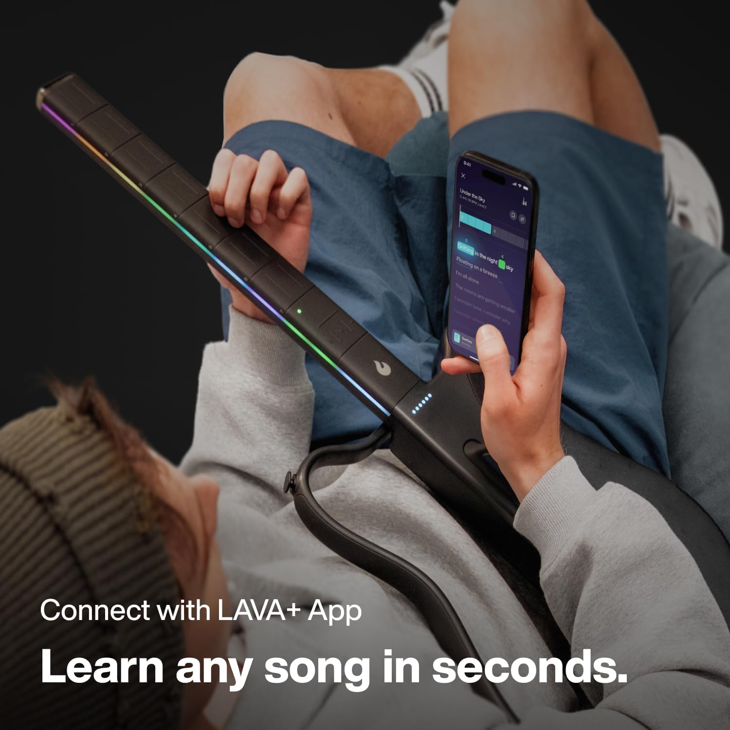 Person holds a guitar with glowing strings and a smartphone displaying lyrics.