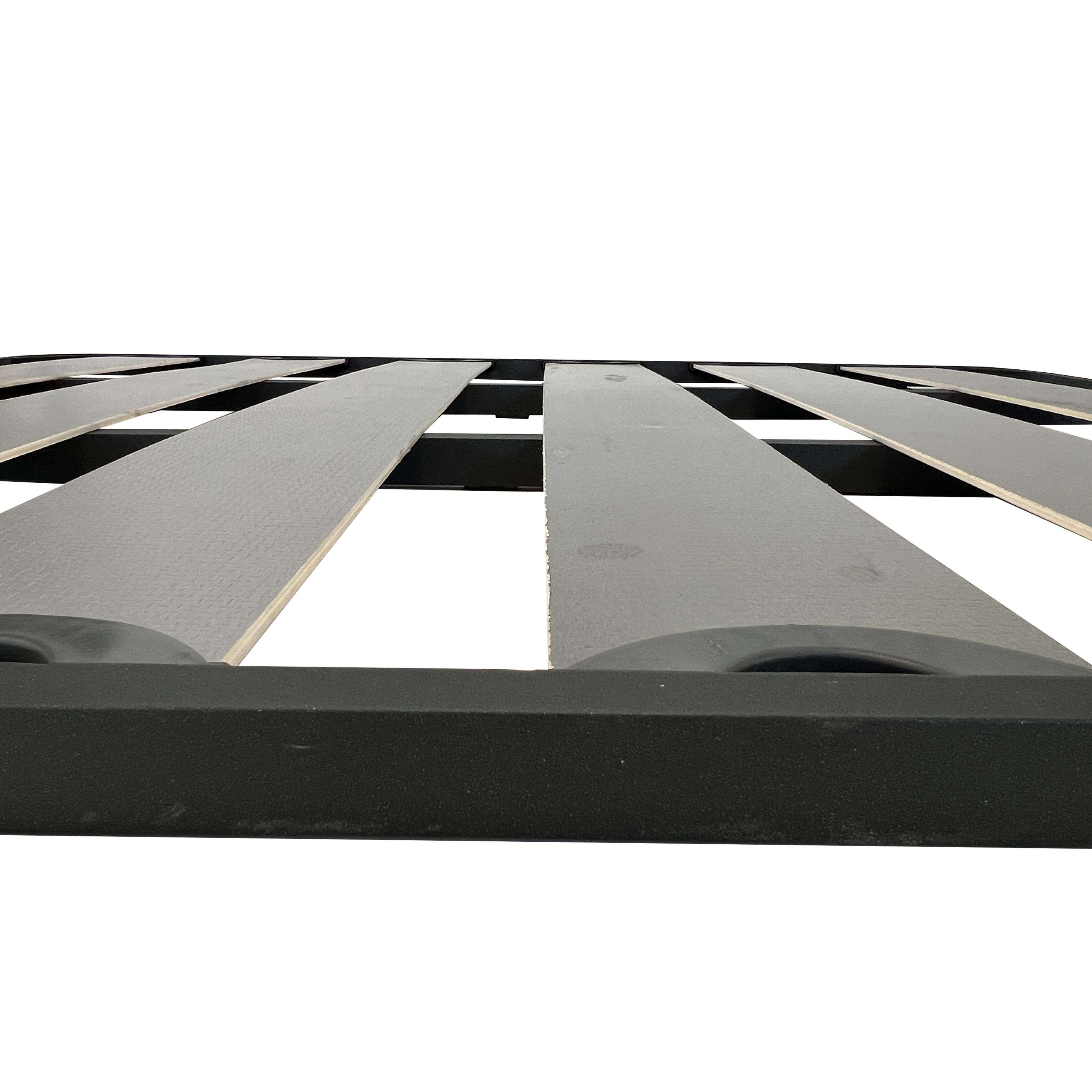 Somier de lamas de madera con marco de metal negro, vista cercana.