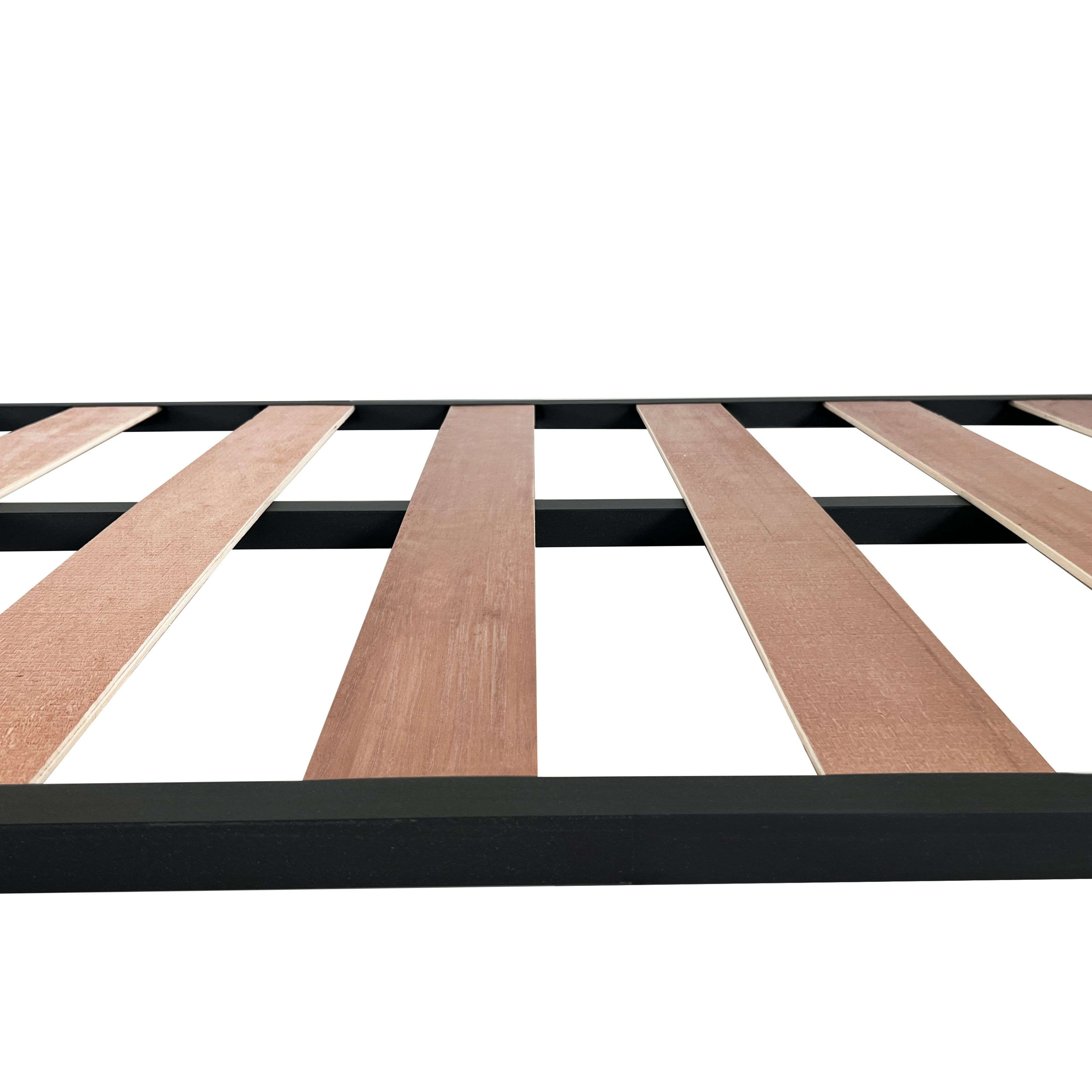Primer plano de un marco de metal negro con listones de madera para una cama.