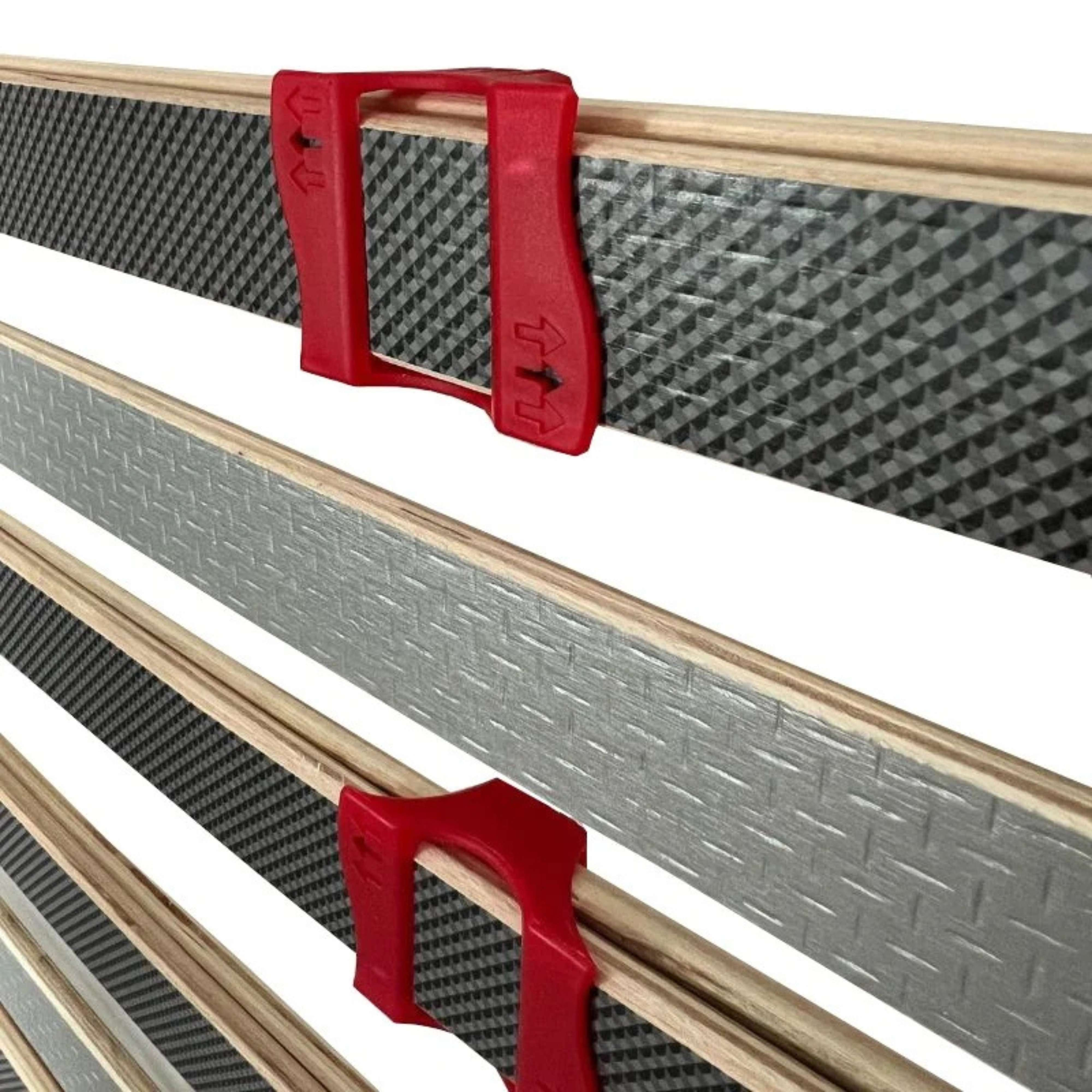 Dos clips rojos sobre listones de madera con patrones.