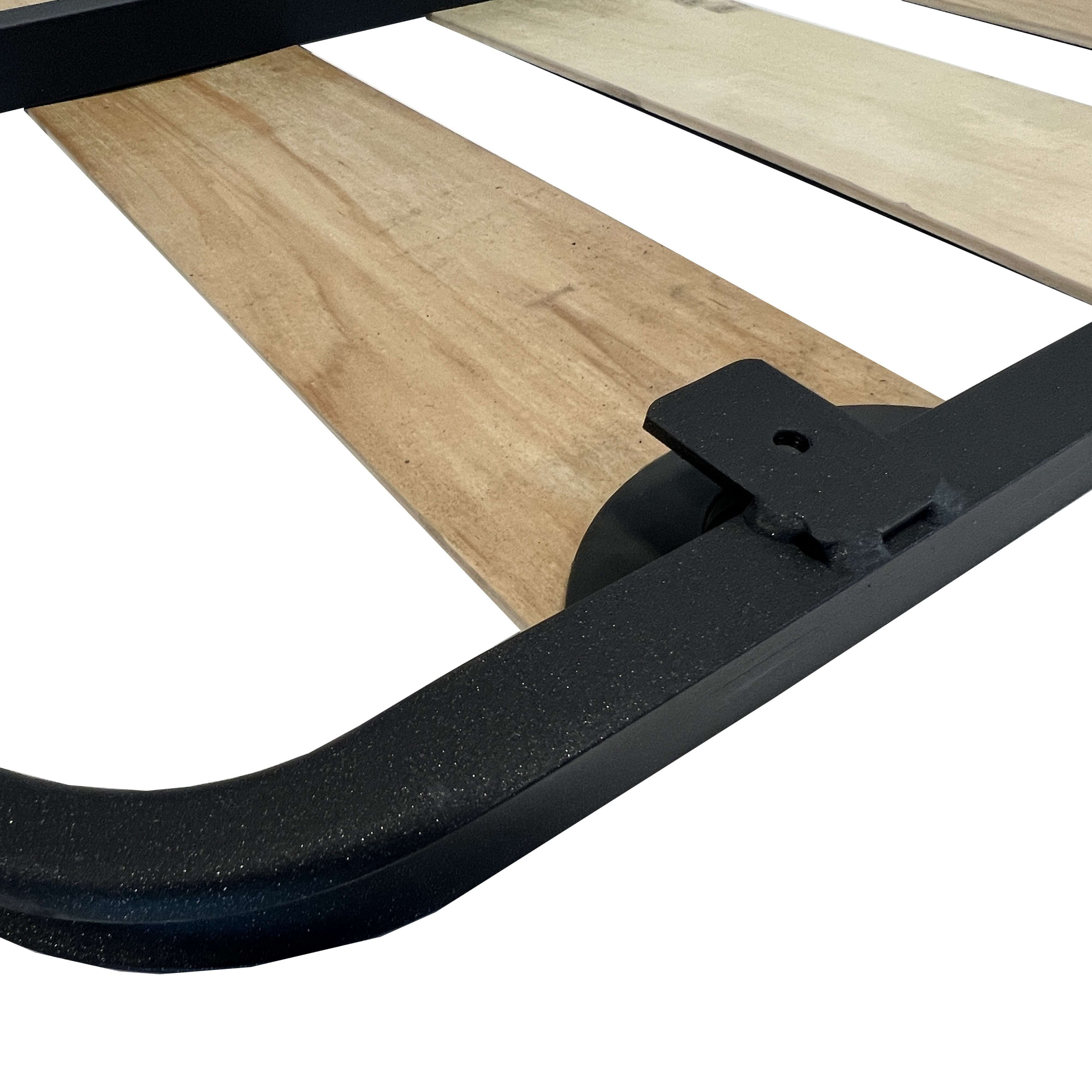 Primer plano de un marco de metal negro y listones de madera de una base de cama.