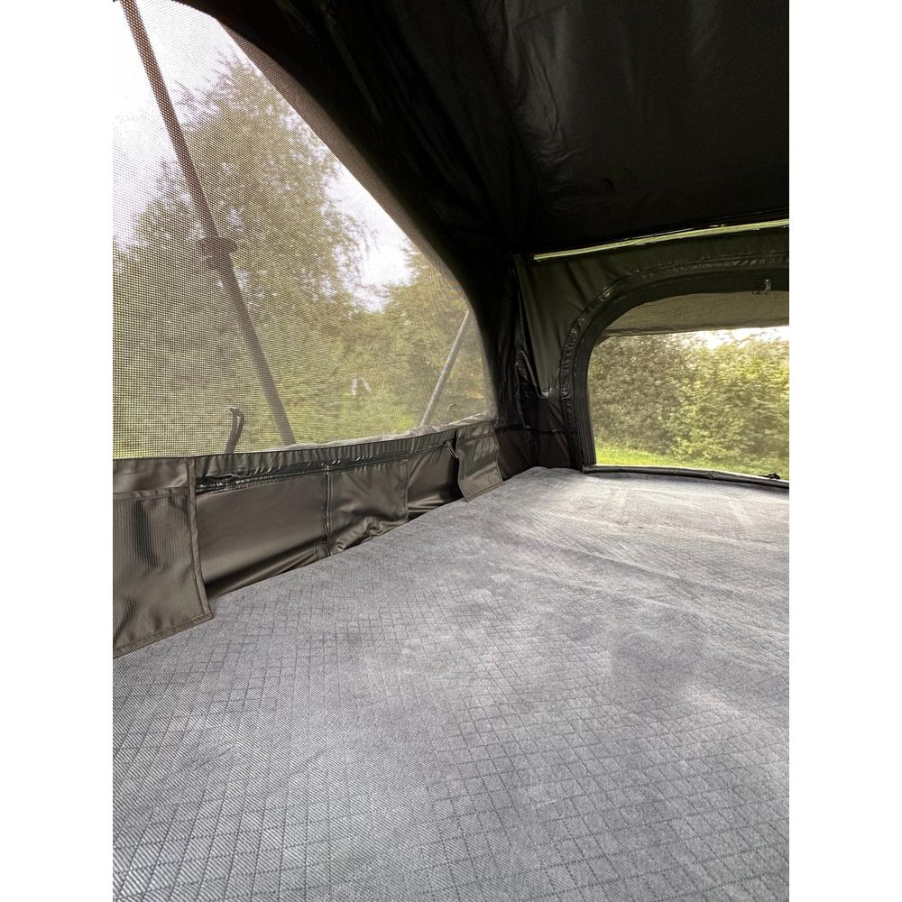 Letto in tenda da tetto con zanzariera, vista sul verde