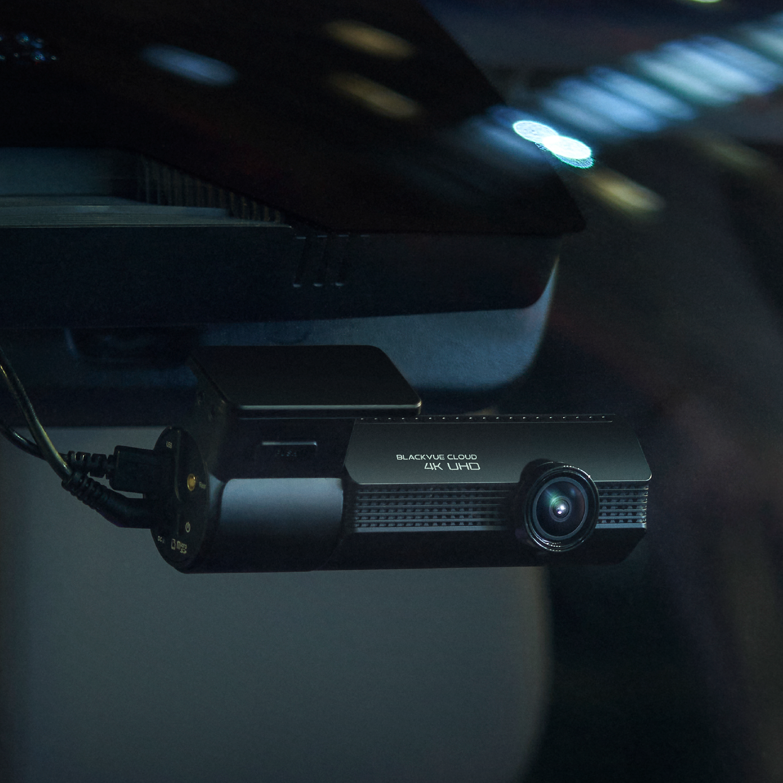 BlackVue Cloud 4K UHD dashcam gemonteerd op voorruit auto. Kabels aangesloten aan de zijkant.