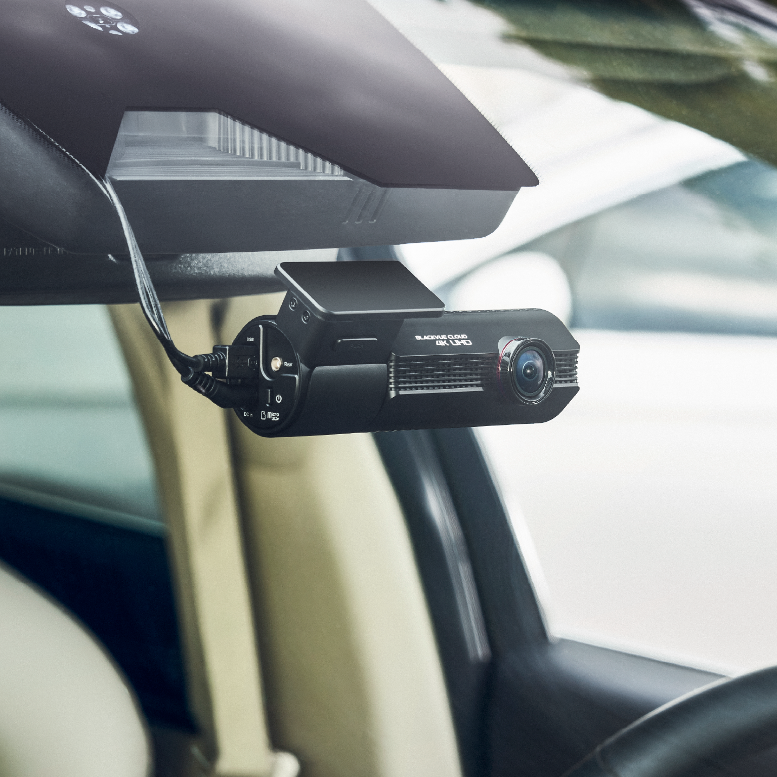 Zwarte 4K UHD dashcam met kabels, bevestigd aan de voorruit van een auto.