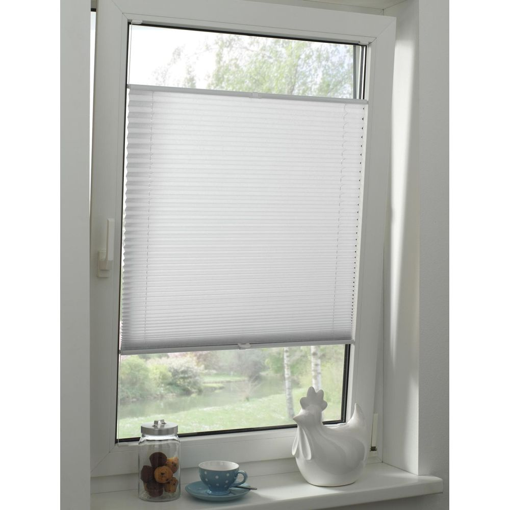 Fenster mit weißen Plissees, Glasbehälter mit Keksen, Tasse und Hühnerfigur.