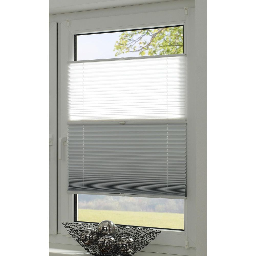 Ein Fenster mit weißen und grauen Plissees. Unten ein schwarzer Korb mit Kugeln.
