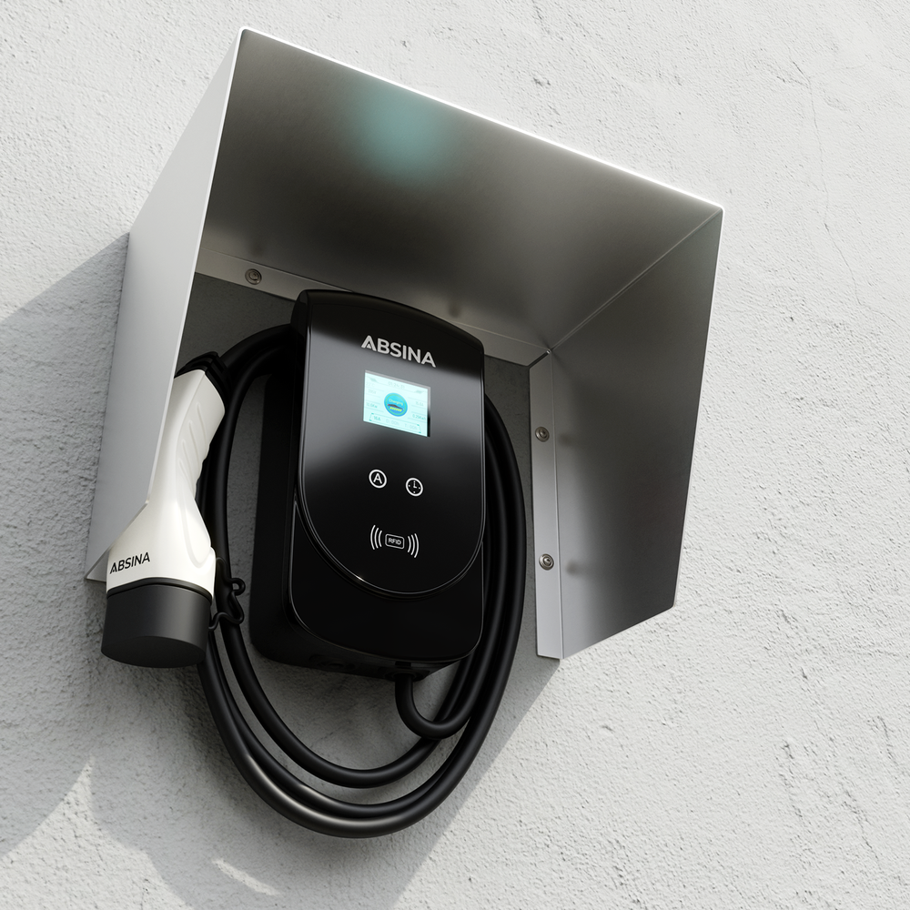Schwarzes ABSINA Ladegerät mit weißem Stecker, an einer Wand montiert unter einem Metallschutzdach.