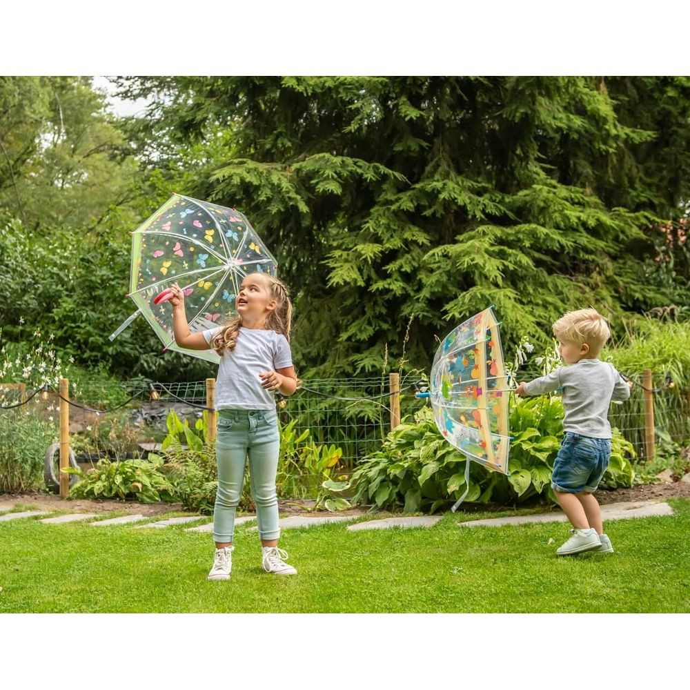 Zwei Kinder spielen mit bunten Schirmen im Garten.