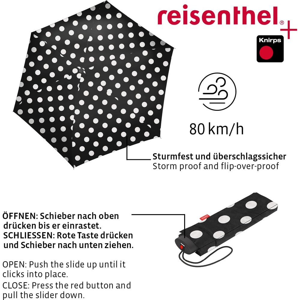 Ein schwarzer Regenschirm mit weißen Punkten, sturmfest bis 80 km/h.