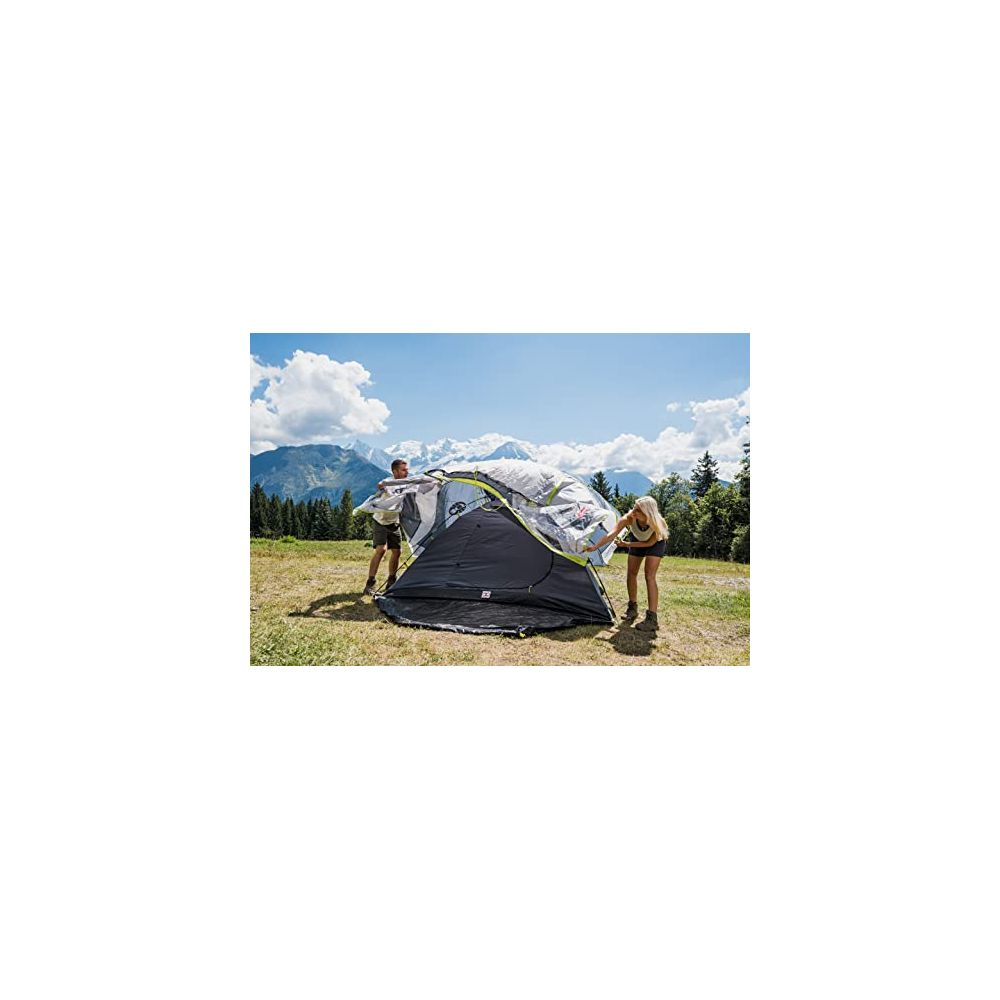 Uomo e donna montano una tenda in un paesaggio montano.