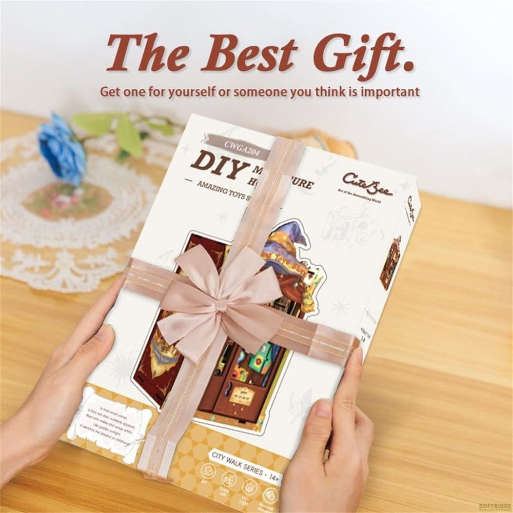Des mains tiennent une boîte cadeau nouée d'un ruban rose. Texte : The Best Gift.