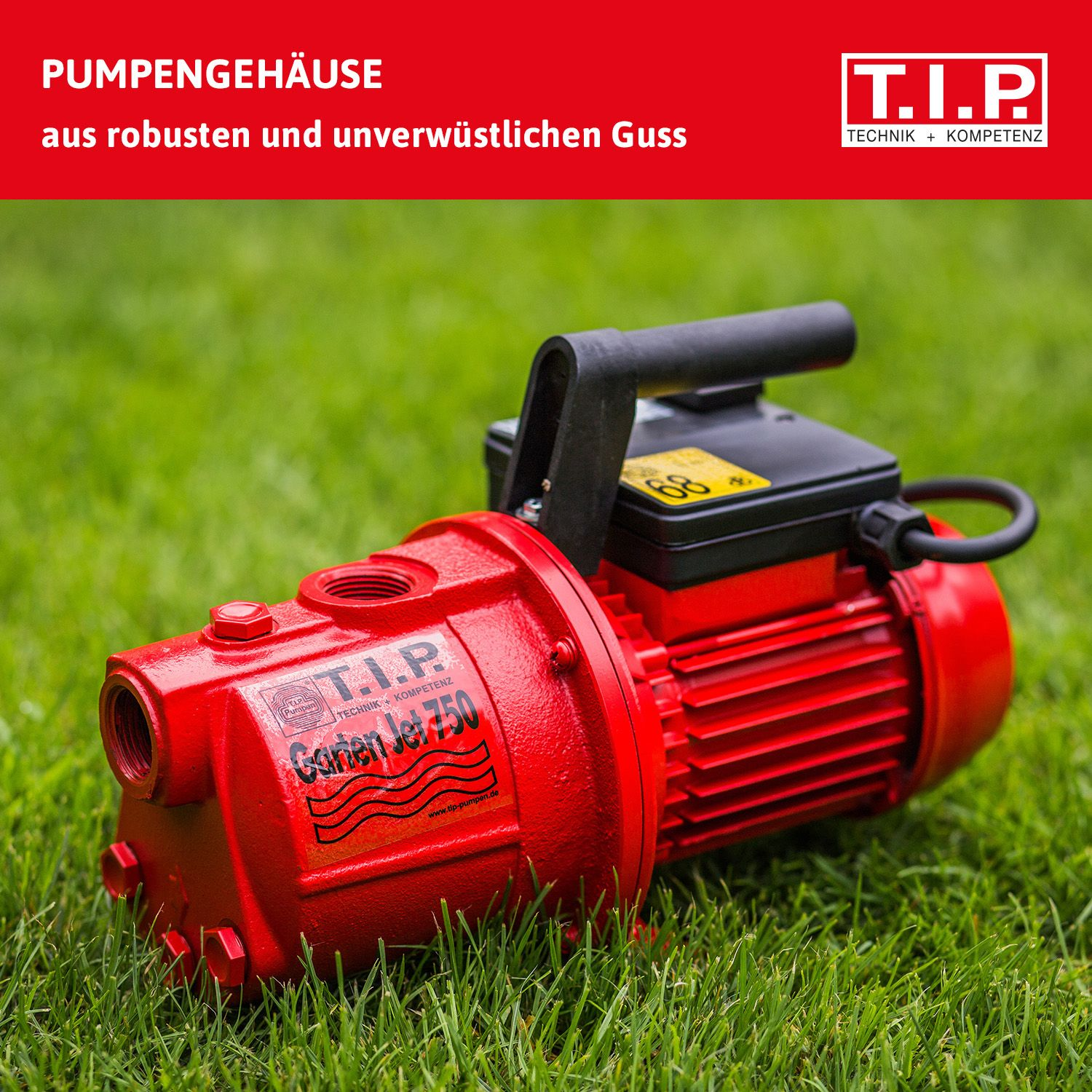Rote Gartenpumpe mit schwarzem Griff und Kabel auf Gras.