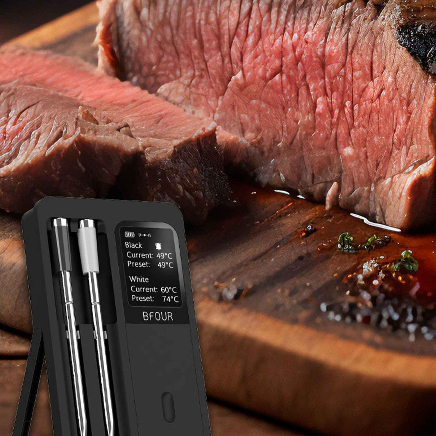 Ein digitales Fleischthermometer zeigt Temperaturen neben einem gebratenen Rinderbraten auf einem Holzbrett an.