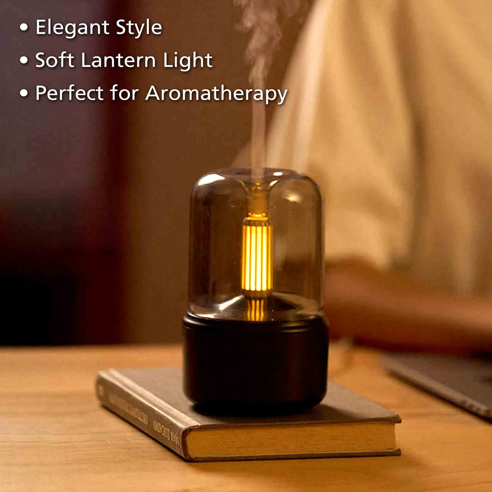 Ein Aromadiffusor mit Glaskuppel und gelbem Licht auf einem Buch.