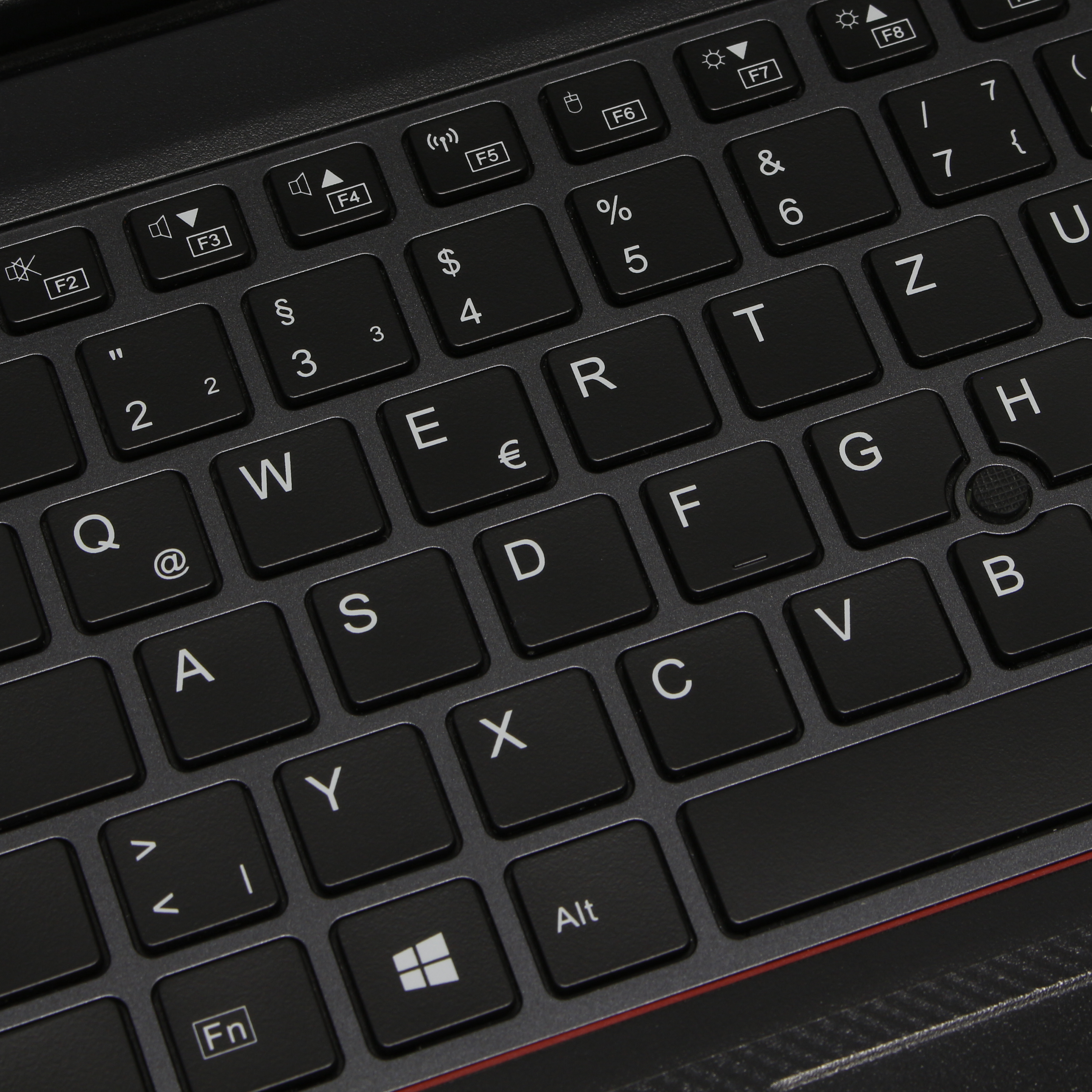 Eine Nahaufnahme einer schwarzen Tastatur mit weißen Buchstaben und Symbolen.