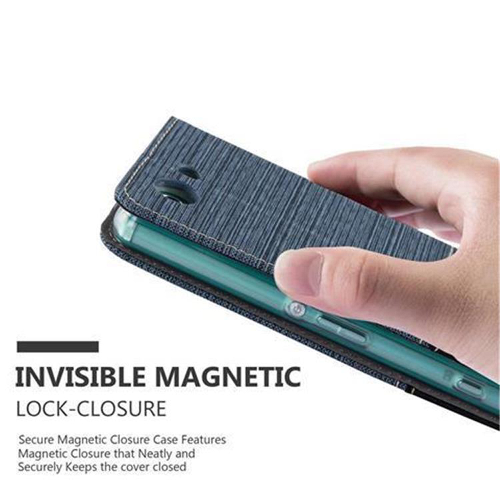 Una mano sostiene una funda de teléfono de tela azul con cierre magnético sobre un smartphone.