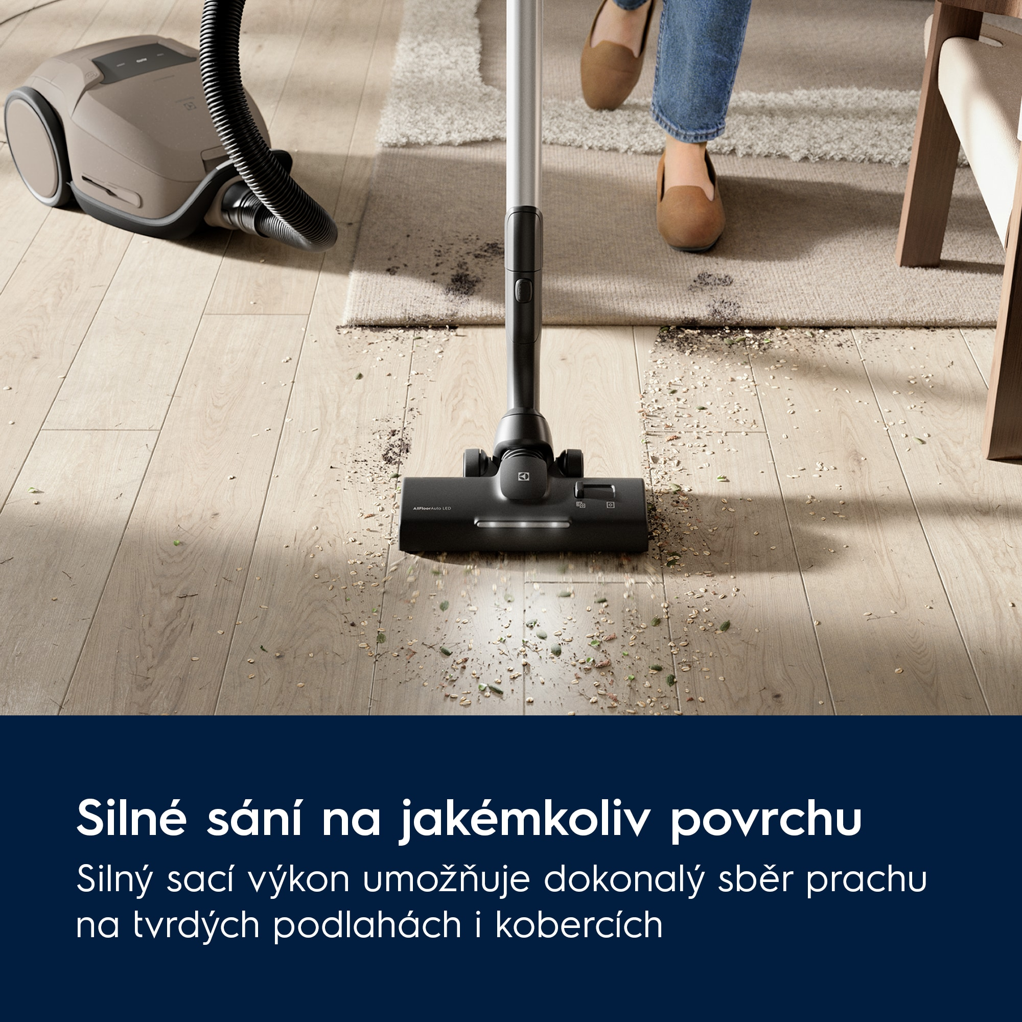 Un aspirapolvere pulisce un pavimento in legno e un tappeto, raccogliendo detriti.