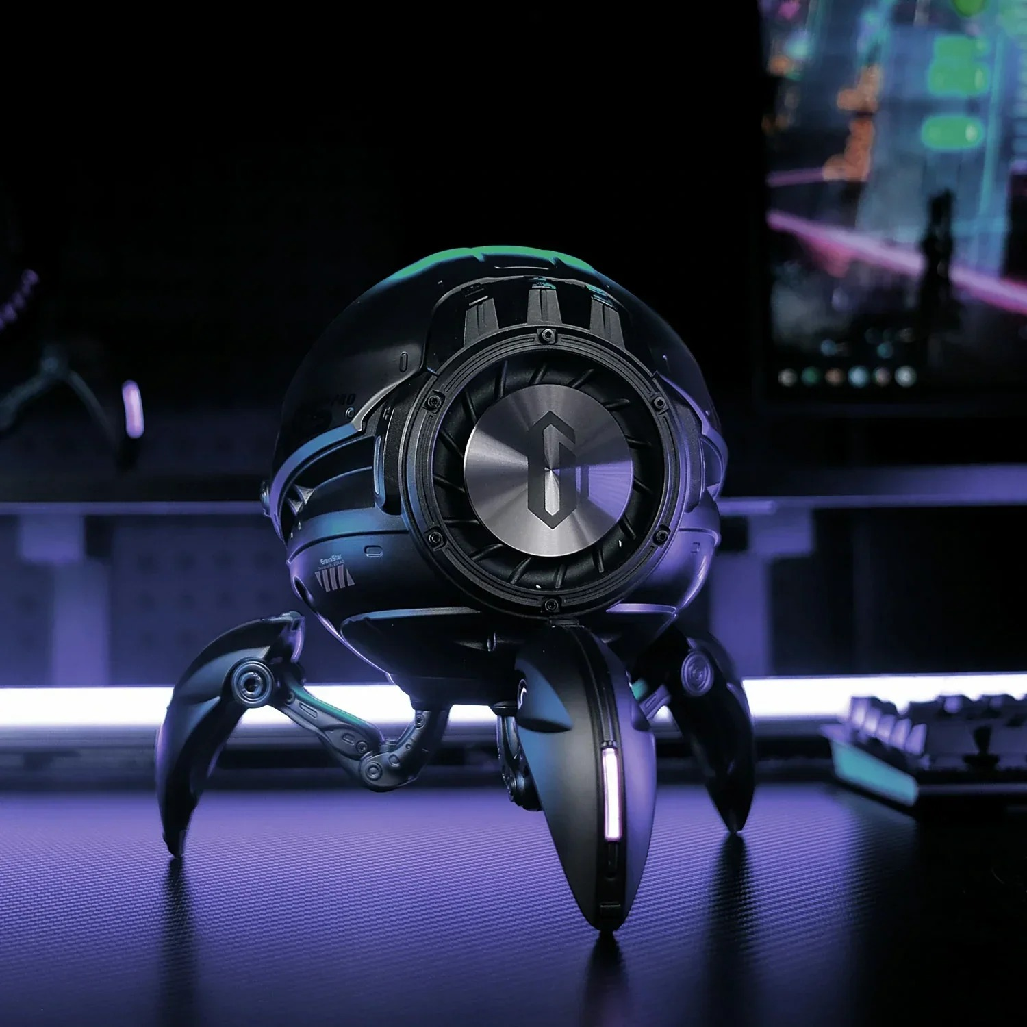 Czarny, futurystyczny głośnik z trzema nogami siedzi na ciemnej powierzchni.