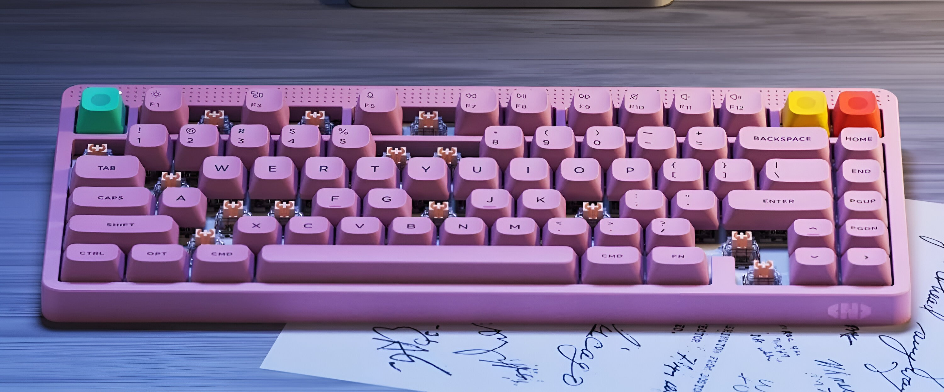 Różowa klawiatura z kolorowymi klawiszami u góry i na dole. Na papierze.