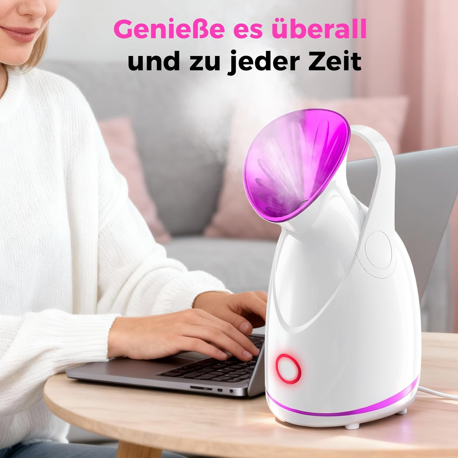 Eine Frau tippt auf einem Laptop, neben ihr ein weißer Gesichtssteamer mit lila Akzenten.