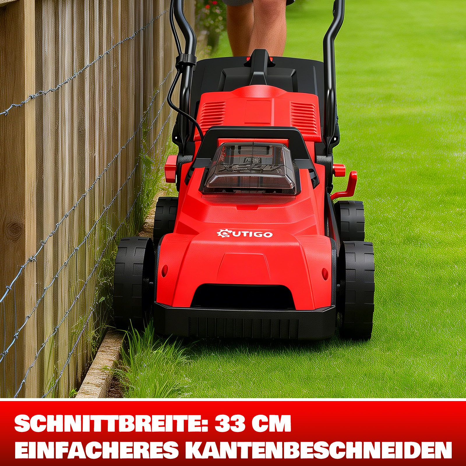 Roter Rasenmäher am Rand eines grünen Rasens neben einem Holzzaun.