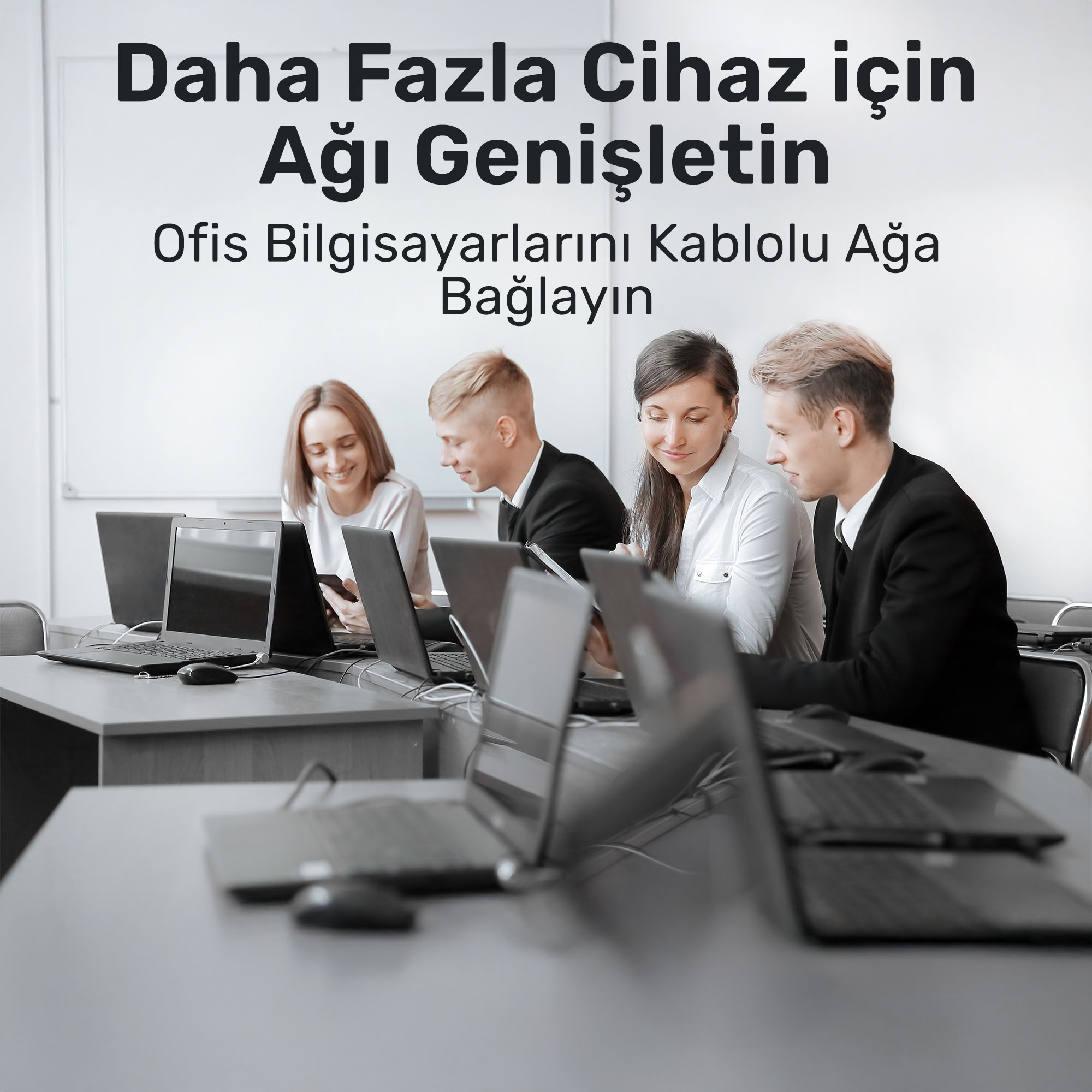 Vier mensen zitten aan bureaus te werken op laptops. Ze glimlachen.