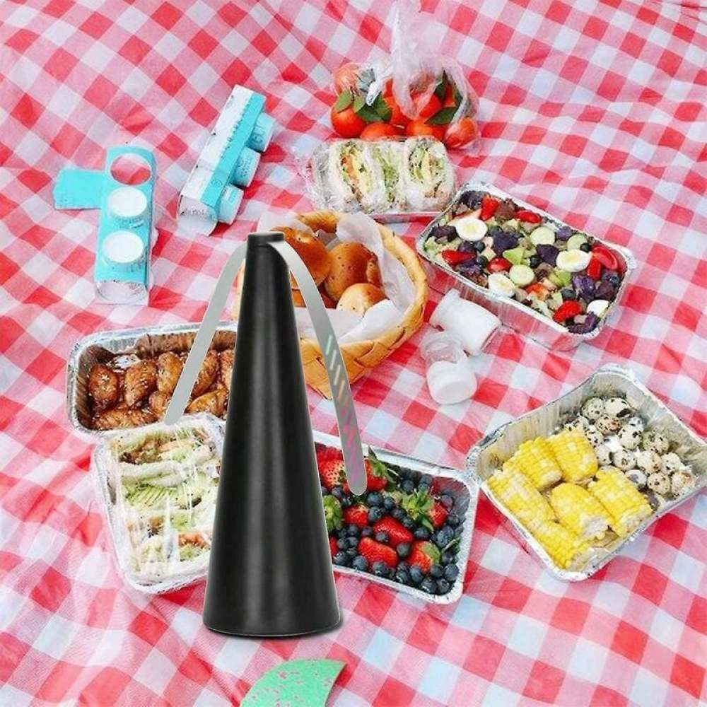 Ein schwarzer Fliegenvertreiber auf einer Picknickdecke mit Essen wie Hühnchen, Früchten und Sandwiches.
