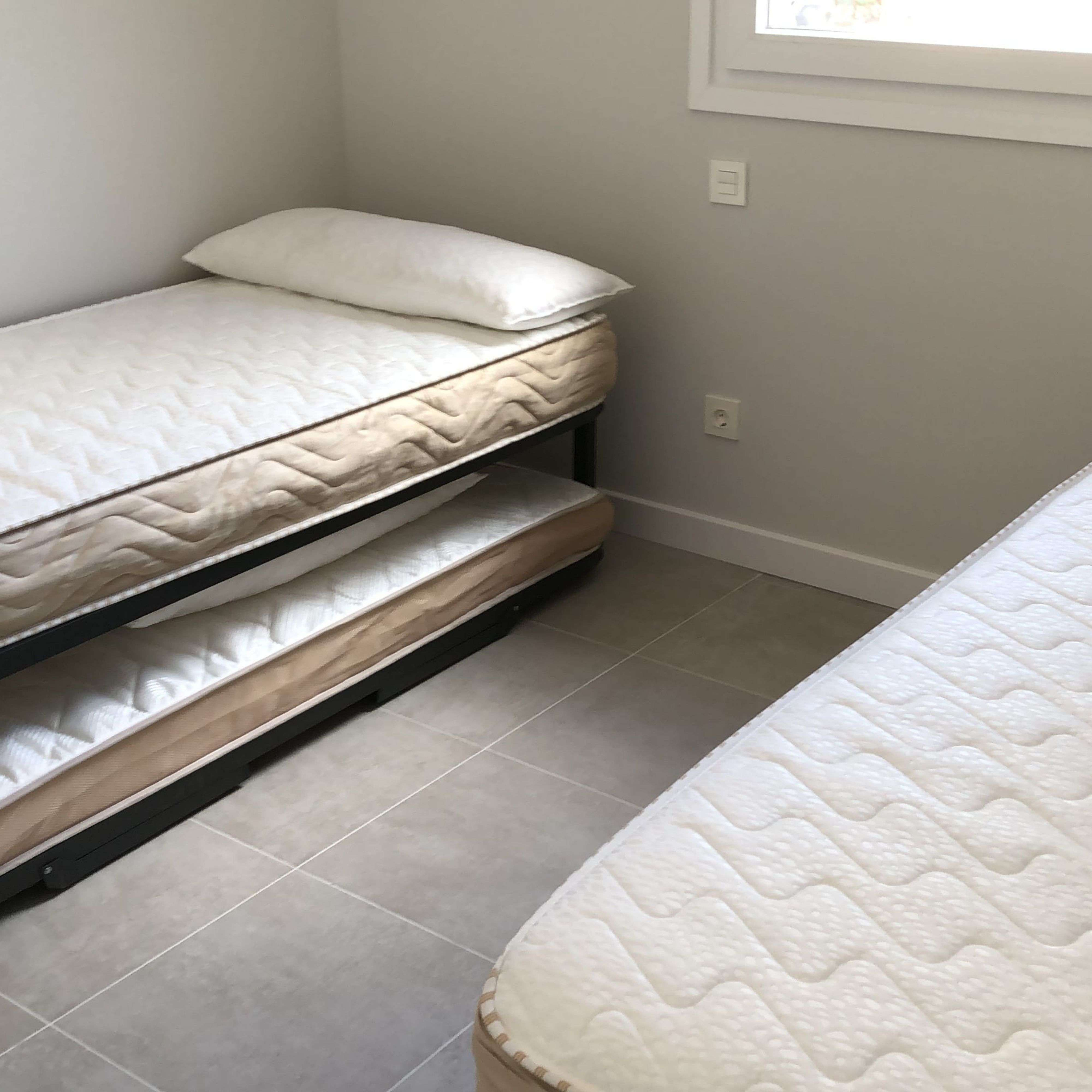 Un dormitorio con dos camas individuales y una cama nido.