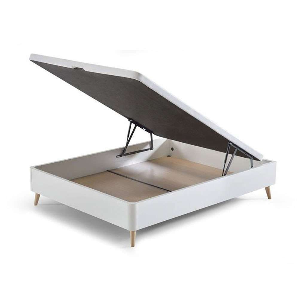 Una base de cama blanca con el somier levantado, revelando espacio de almacenamiento debajo.