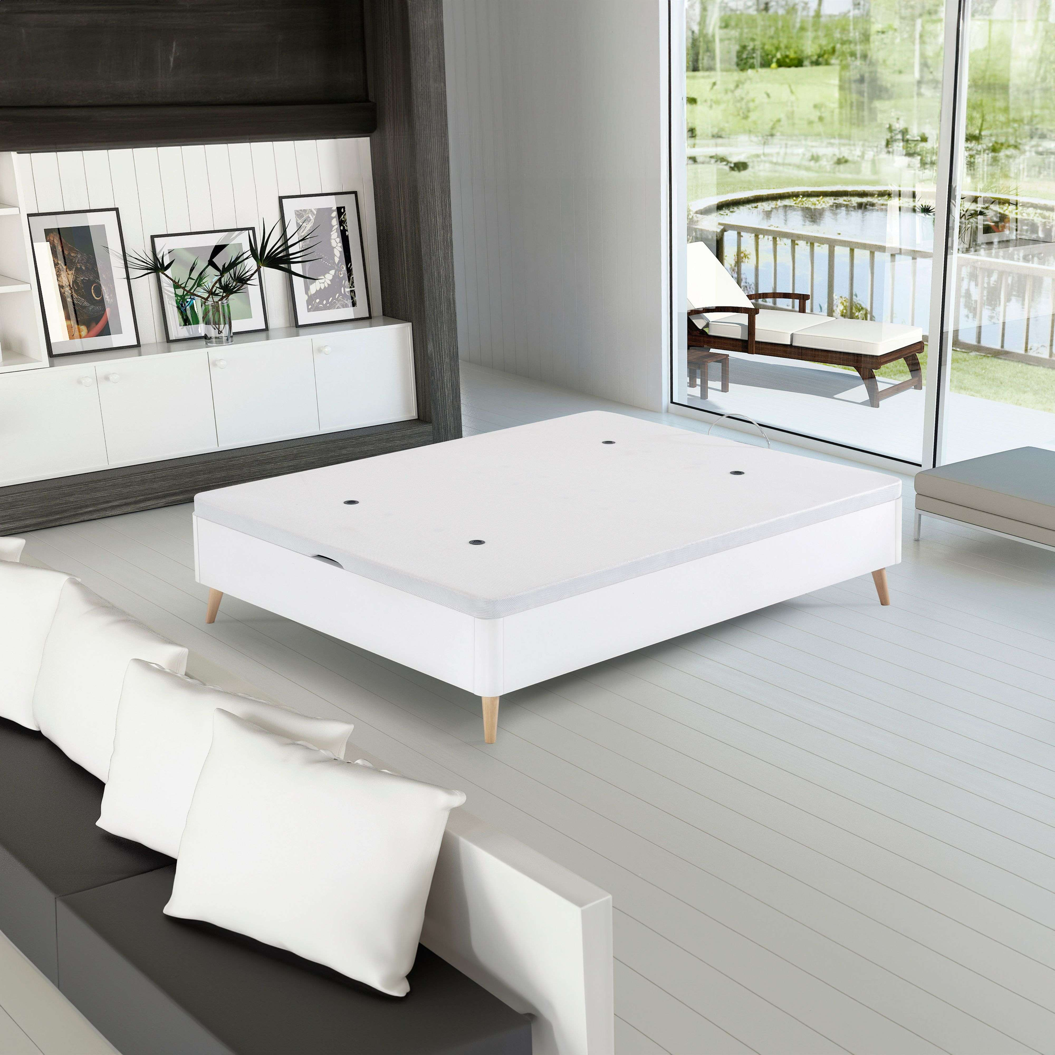 Dormitorio moderno con somier blanco, sofás y vistas a un estanque.