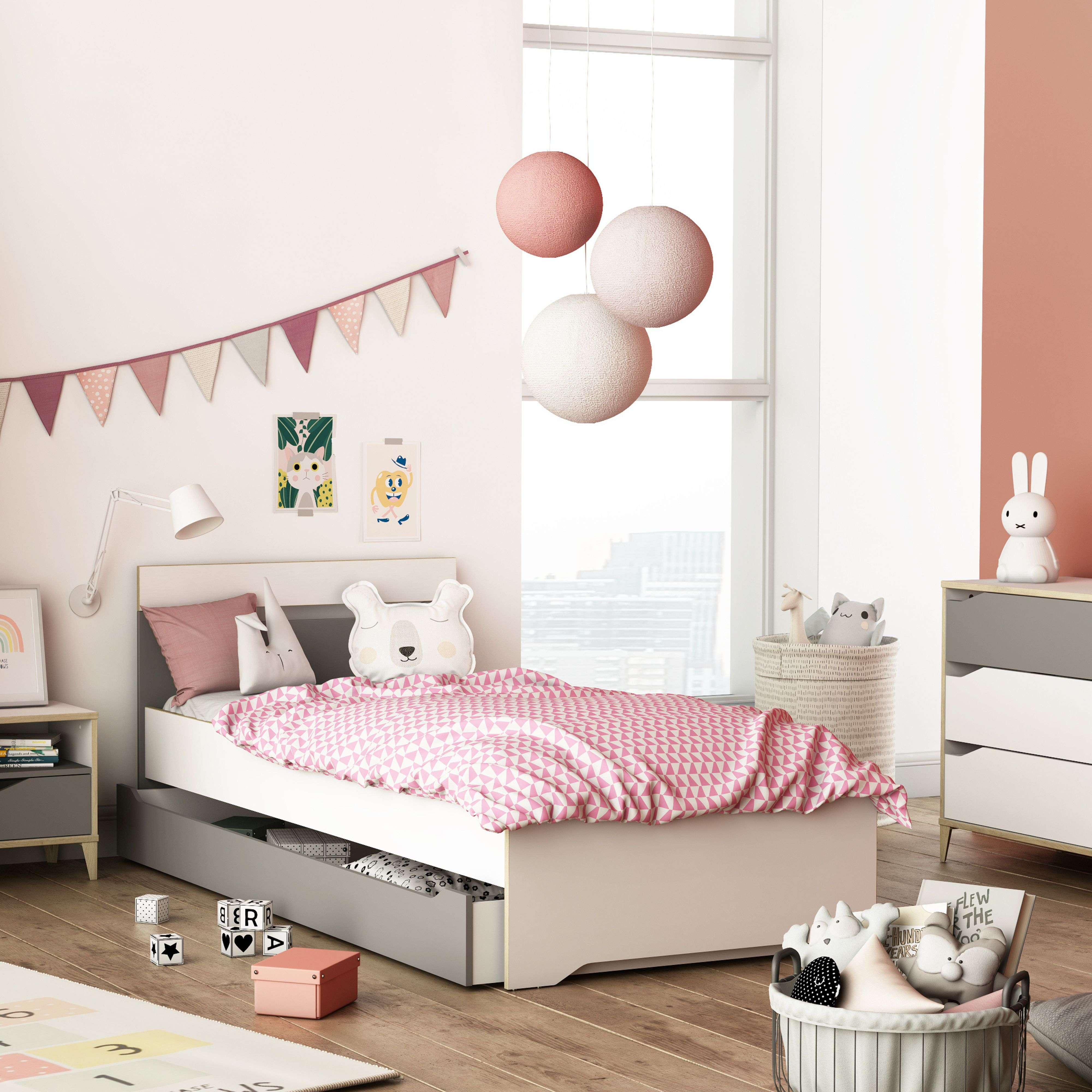 Un dormitorio infantil con cama, juguetes y una guirnalda de banderines.